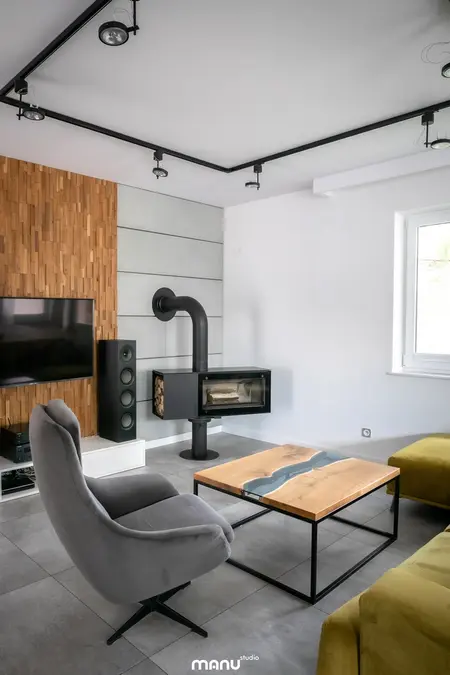Wnętrze salonu z elementami industrialnymi i minimalistycznymi, w nowoczesnym stylu.