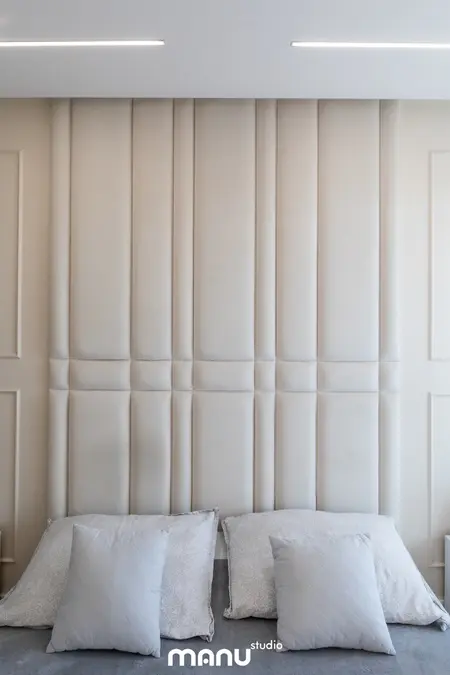 Wnętrze sypialni z beżowym zagłówkiem, szarymi poduszkami, styl art deco, nowoczesny, quiet luxury.