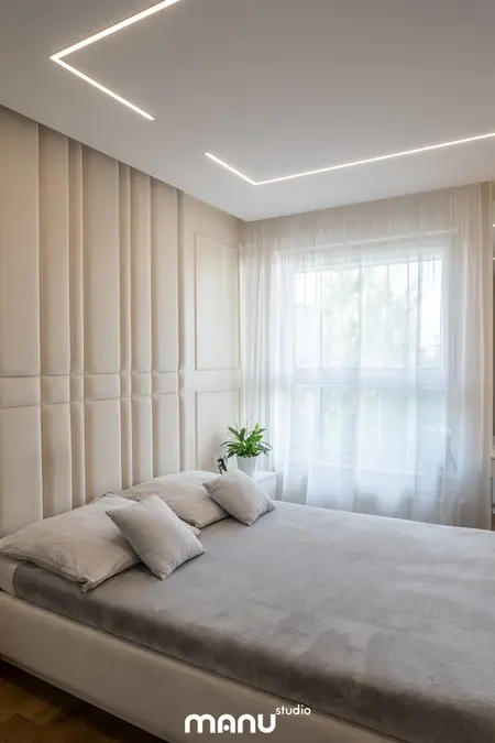 Wnętrze sypialni z jasnymi ścianami, nowoczesnym łóżkiem i rośliną. Styl art deco, quiet luxury, tradycyjny.