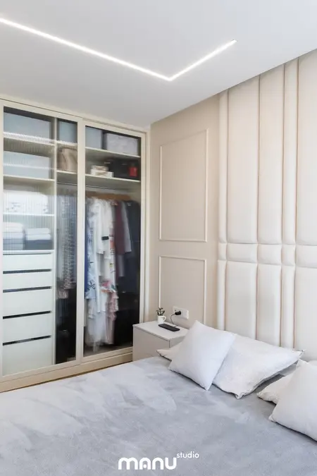 Wnętrze sypialni z białą szafą, szarym łóżkiem i nowoczesnym oświetleniem. Styl: art deco, nowoczesny, quiet luxury, tradycyjny, współczesny.