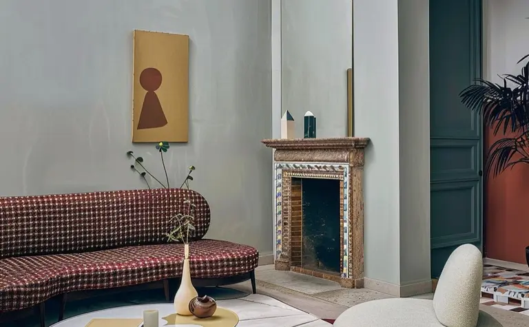 Wnętrze salonu z art deco i minimalistycznym designem, brązowa sofa, okrągły stół.