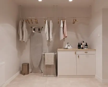 Pralnia minimalistyczna z białymi meblami i nowoczesnym wyposażeniem.