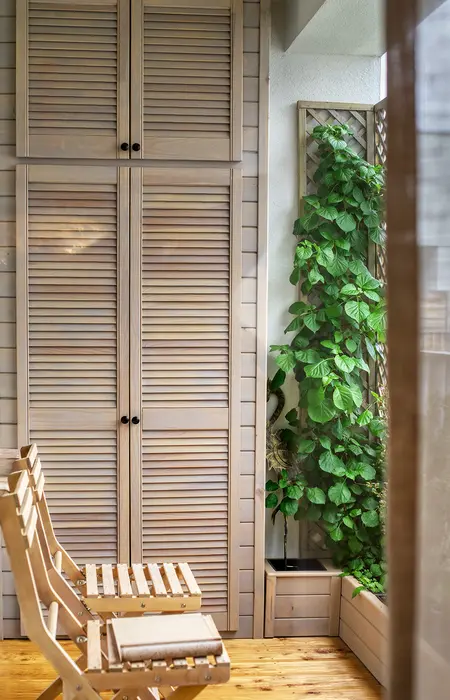 Balkon w stylu boho z drewnianymi meblami i roślinnością