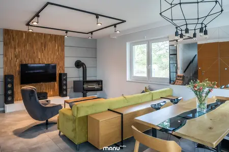Wnętrze salonu w stylu industrialnym i skandynawskim z drewnianą ścianą.