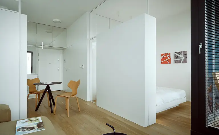 Minimalistyczne wnętrze z białymi ścianami i drewnianymi meblami, styl minimaluxe.