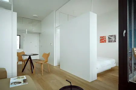 Minimalistyczne wnętrze z białymi ścianami i drewnianymi meblami, styl minimaluxe.