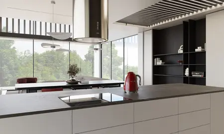 Minimalistyczna, nowoczesna kuchnia z dużymi oknami, czerwonym czajnikiem i drewnianym blatem.