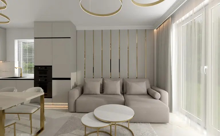Nowoczesny salon z beżową sofą, złotymi detalami na ścianie i marmurowymi stolikami kawowymi. Jasne wnętrze o minimalistycznym wystroju, z dużymi oknami i złotym oświetleniem.