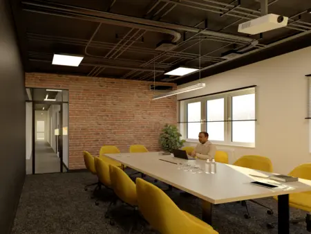 Sala konferencyjna z ceglaną ścianą i żółtymi krzesłami, styl industrialny.
