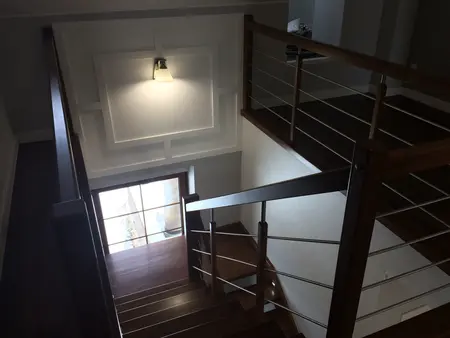 Widok korytarza z drewnianymi schodami, nowoczesny i tradycyjny design.