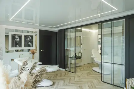Wnętrze w stylu glamour z nowoczesnymi akcentami, biały stół i czarne ściany.