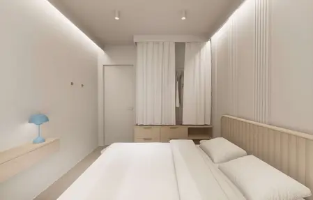 Minimalistyczna sypialnia z elementami japandi i quiet luxury, jasne kolory, drewniane akcenty.