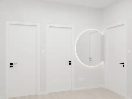 Minimalistyczny korytarz z białymi drzwiami i nowoczesnym lustrem.