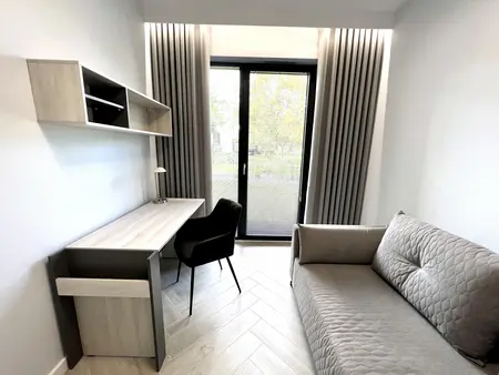 Gabinet w stylu boho i współczesnym z biurkiem, sofą, zasłonami.
