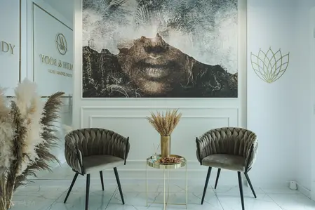 Nowoczesne wnętrze z obrazem, zielonymi fotelami i dekoracjami w stylu glamour.