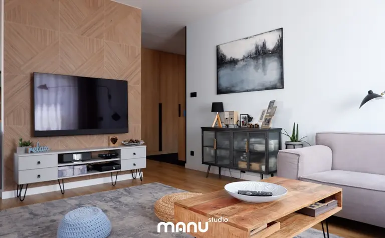 Wnętrze salonu z nowoczesnym telewizorem i skandynawskim stołem.