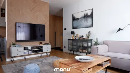 Wnętrze salonu z nowoczesnym telewizorem i skandynawskim stołem.