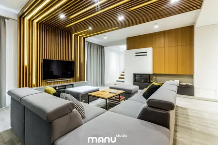 Wnętrze salonu w stylu industrialnym z drewnianą ścianą i minimalistycznym umeblowaniem.