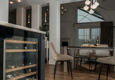 Wnętrze jadalni z nowoczesnym stołem i tradycyjnymi krzesłami w stylu quiet luxury.