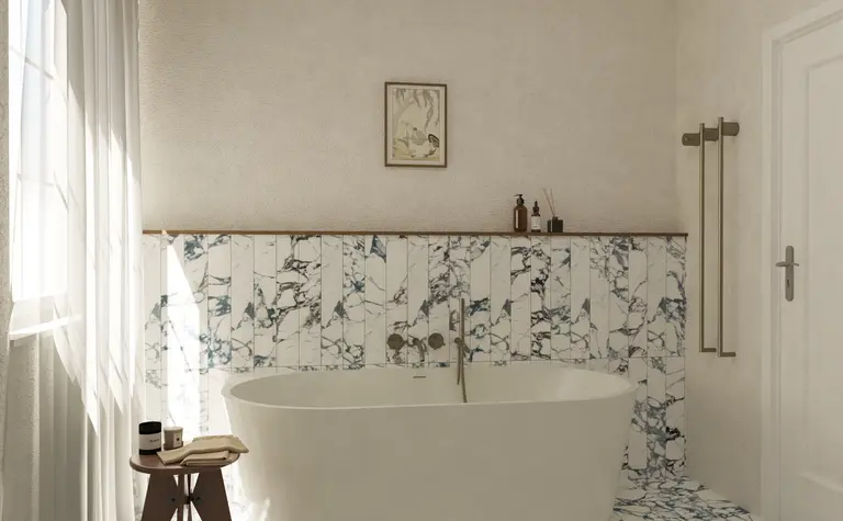 Wnętrze łazienki w stylu soft minimalizm i vintage z wanną oraz marmurowymi płytkami.