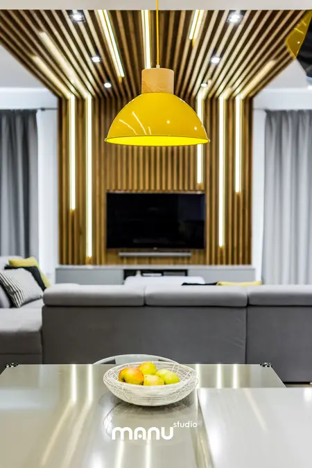 Salon w stylu industrialnym z minimalistycznym oświetleniem i drewnianą dekoracją.