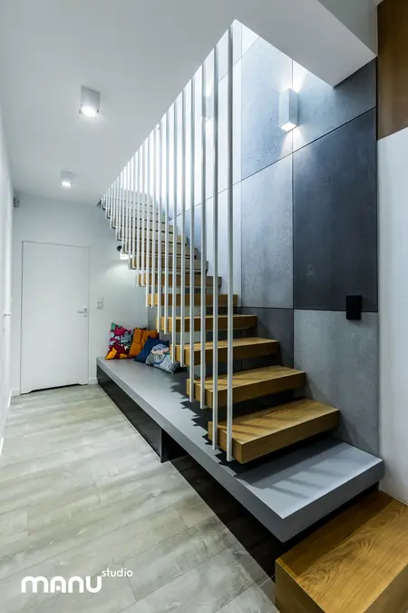 Wnętrze wejścia z industrialnymi schodami, minimalistycznym designem i skandynawskimi detalami.