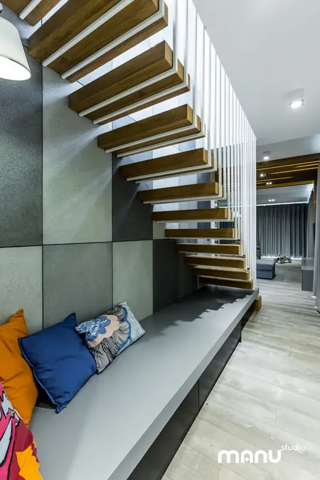 Wnętrze z drewnianymi schodami i poduszkami w stylu industrialnym, minimalistycznym i skandynawskim.
