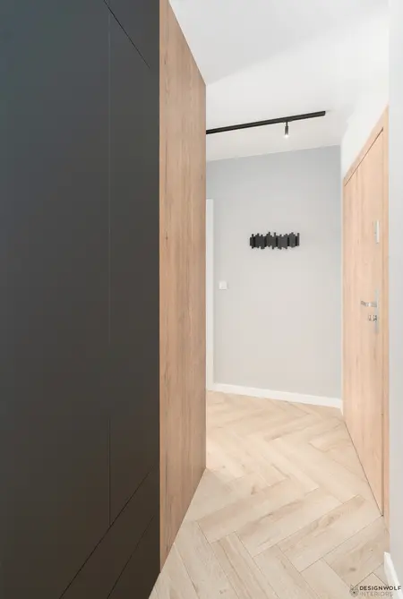 Korytarz w stylu industrialnym z drewnianymi ścianami i czarnymi detalami