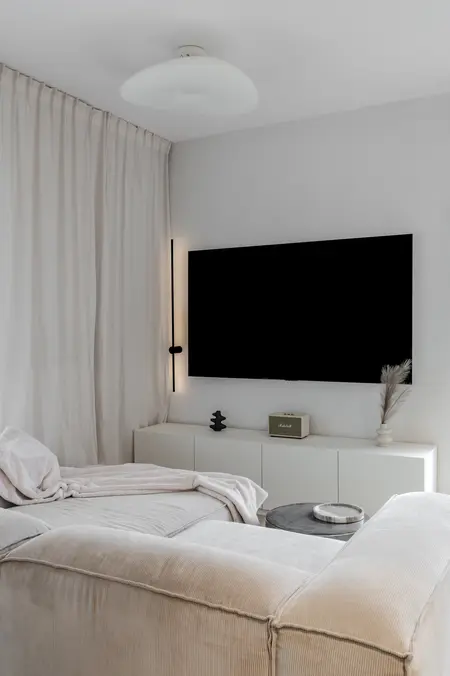 Wnętrze salonu w stylu art deco i boho z białą sofą.