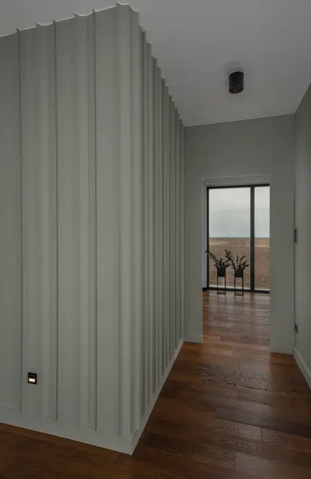 Korytarz w stylu minimalistycznym z zielonymi ścianami i drewnianą podłogą, nowoczesny design.