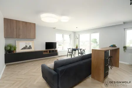 Wnętrze salonu w stylu industrialnym z drewnianym blatem i roślinami.