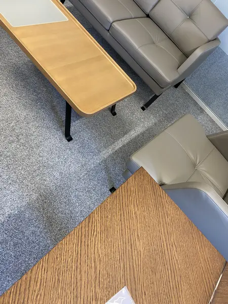 Wnętrze salonu z szarymi meblami i drewnianym stolikiem w stylu industrialnym.