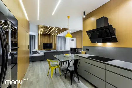 Wnętrze kuchni w stylu industrialnym i skandynawskim z drewnianymi detalami i nowoczesnym oświetleniem.