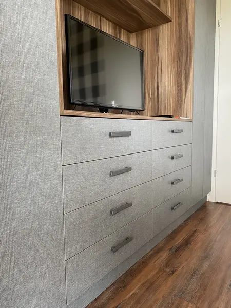 Nowoczesne wnętrze z szarymi meblami i drewnianymi akcentami, styl minimalistyczny i współczesny.