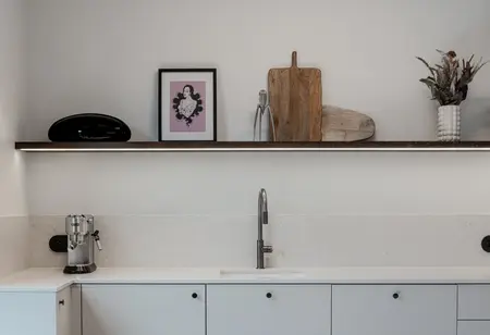 Wnętrze kuchni w stylu art deco, boho i eklektycznym z białymi meblami.