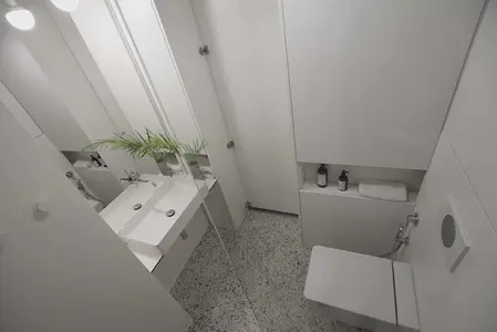 Nowoczesna łazienka z białymi meblami i minimalistycznym designem.