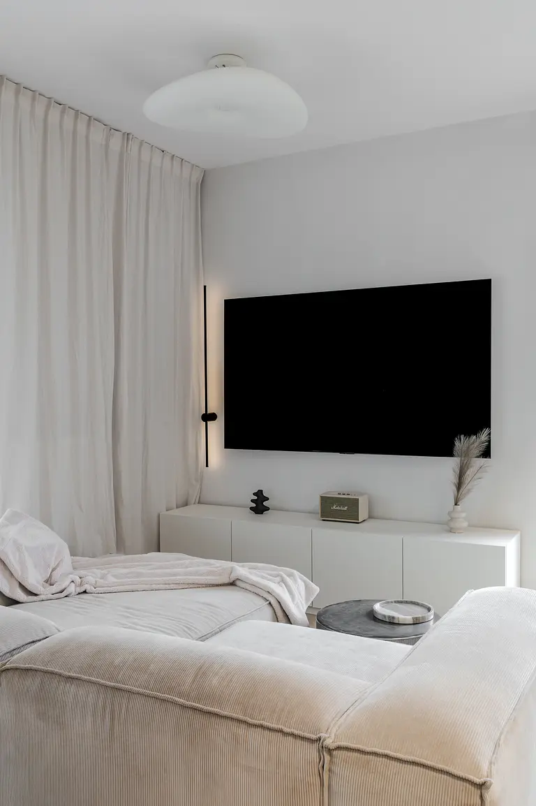 Wnętrze salonu w stylu art deco i boho z białą sofą.