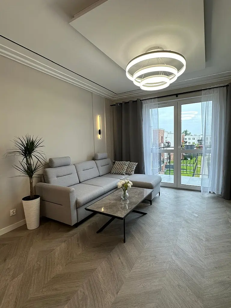 Wnętrze salonu z minimalistycznym wystrojem, nowoczesna sofa i stół.