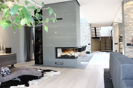Wnętrze salonu z kominkiem, minimalistycznym designem i drewnianymi akcentami.