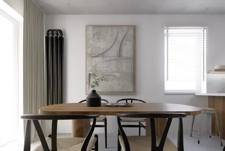 Wnętrze jadalni w stylu industrialnym i minimalistycznym z drewnianym stołem, szarymi akcentami i rośliną.