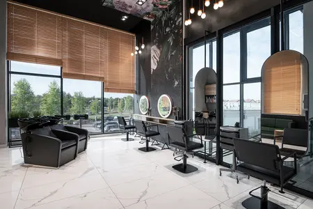 Nowoczesne wnętrze salonu z czarnymi fotelami i dużymi oknami, idealne do relaksu.