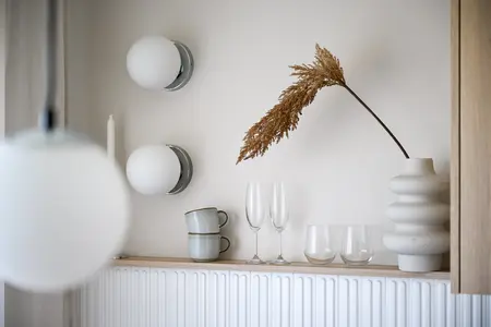 Nowoczesne wnętrze z dekoracjami w stylu japandi, białymi lampami i drewnianymi detalami.