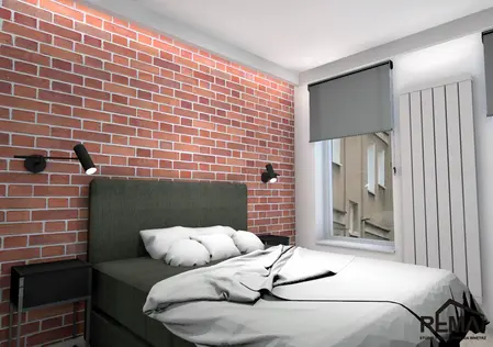 Wnętrze sypialni z ceglaną ścianą, szarym łóżkiem i minimalistycznymi lampami. Styl industrialny.