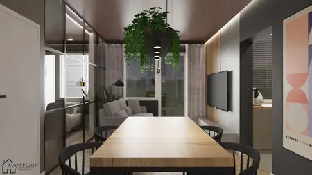 Wnętrze industrialnej jadalni z drewnianym stołem, czarnymi krzesłami i roślinnością.