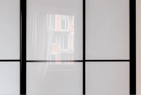 Przeszklona ściana z czarnymi detalami w minimalistycznym wnętrzu
