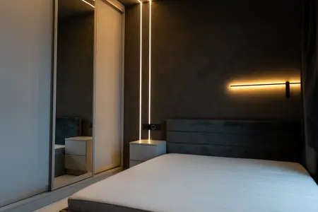 Wnętrze sypialni z nowoczesnym oświetleniem LED i lustrem