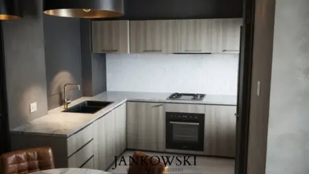Kuchnia z drewnianymi meblami, białą ścianą i szarym blatem, w stylu skandynawskim i minimalistycznym.