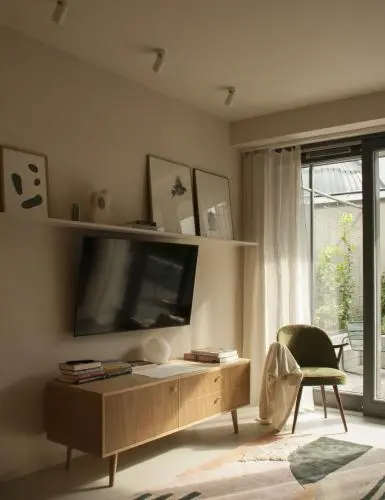 Wnętrze salonu w stylu eklektycznym z telewizorem, komodą i dużymi oknami.