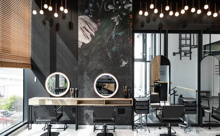 Nowoczesny salon fryzjerski z lustrami i dekoracyjną ścianą