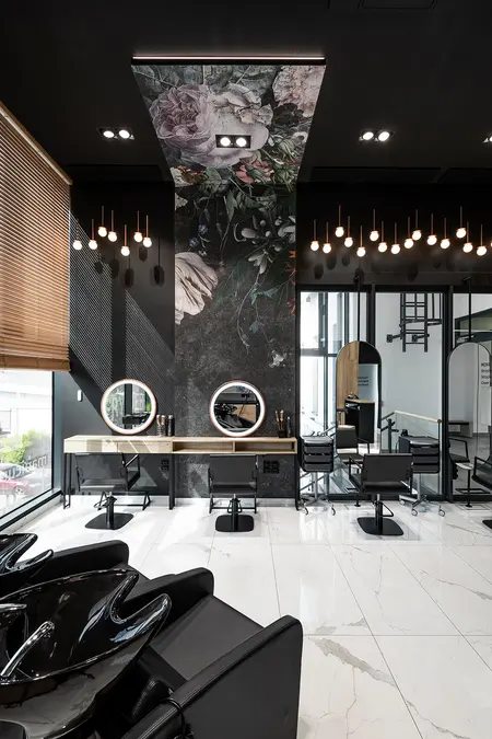 Nowoczesny salon fryzjerski z lustrami i dekoracyjną ścianą